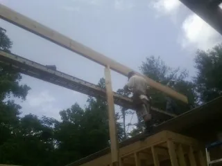 Carpenter setting a ridge beam over a new addition frame — Ice Dam Removal by Roofing Brothers in Summerfield