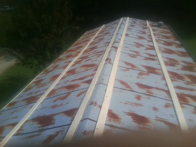 Rusted metal roof panels with new wood purlins before replacement — Storm Damage Roof Repair in Summerfield by Roofing Brothers